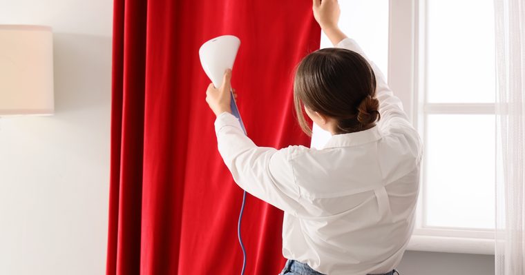 Vaporeta pasando por unas cortinas colgadas en la ventana
