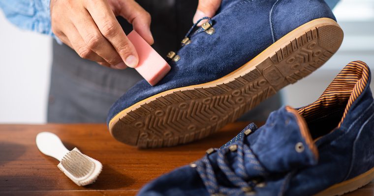 Cepillo de crepé pasando por la piel de ante de un zapato