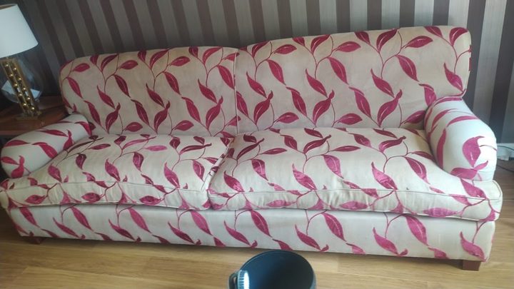 Sofá de tres plazas de tela estampada después de la limpieza