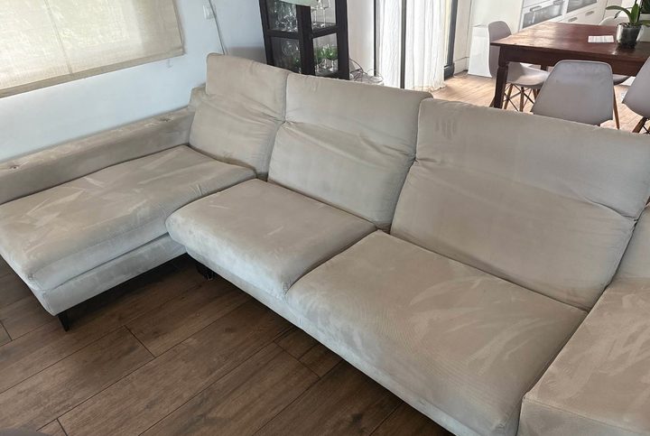 Sofá chaiselongue beige con manchas de uso, antes de la limpieza